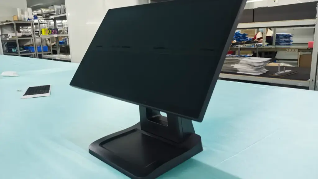 A black desktop POS terminal monitor sitting on a workstation table