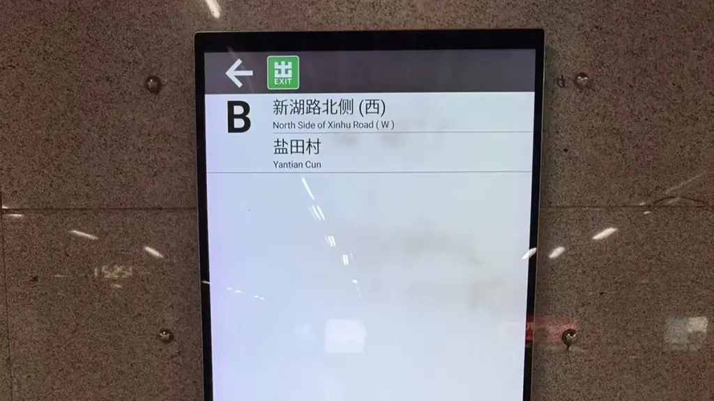 A wall-mounted digital subway station exit directory display with advertisements