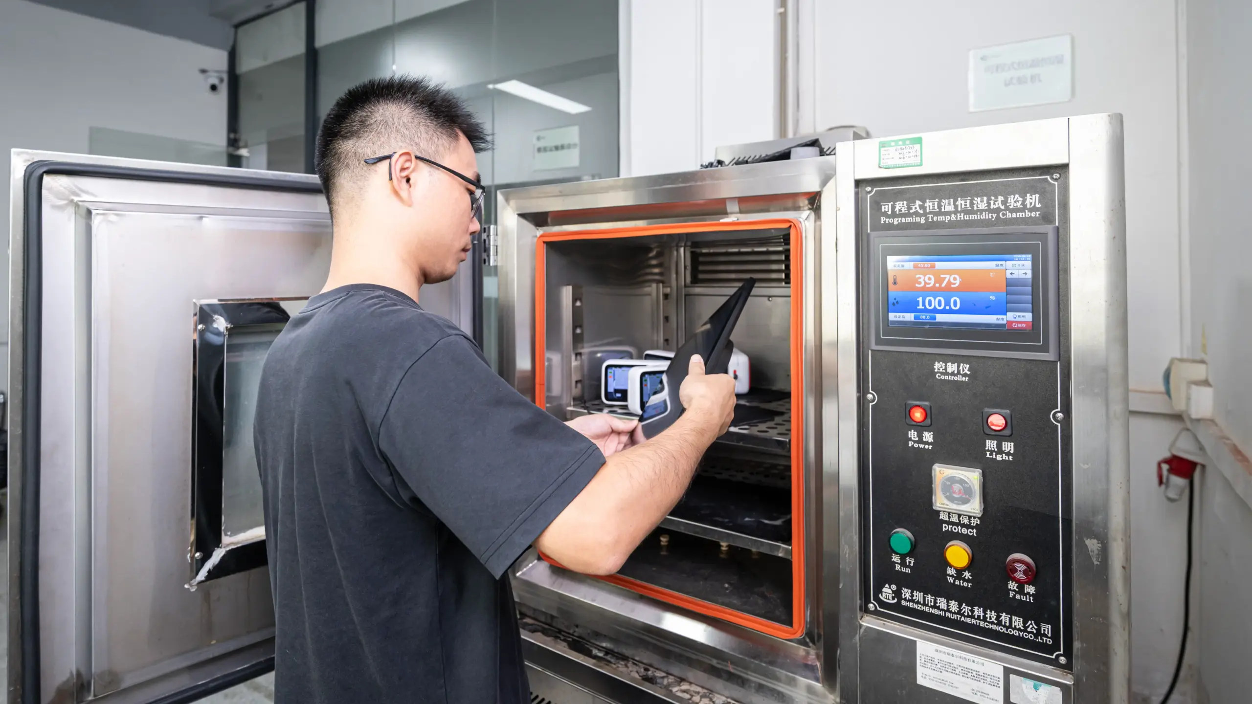 Programmable Temperature and Humidity Testing Chamber Technician inspecting a device at a programmable temperature and humidity testing chamber